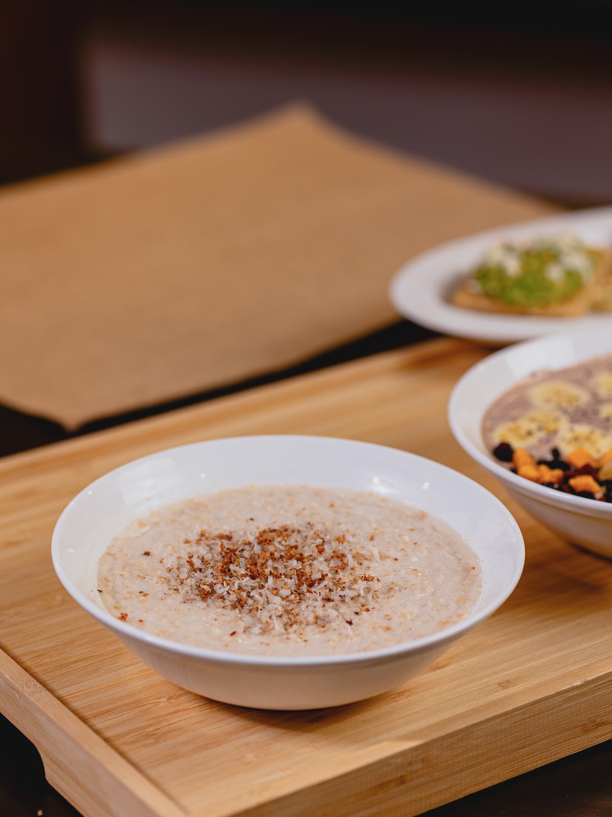 A bowl of cinnamon-dusted porridge on a wooden board