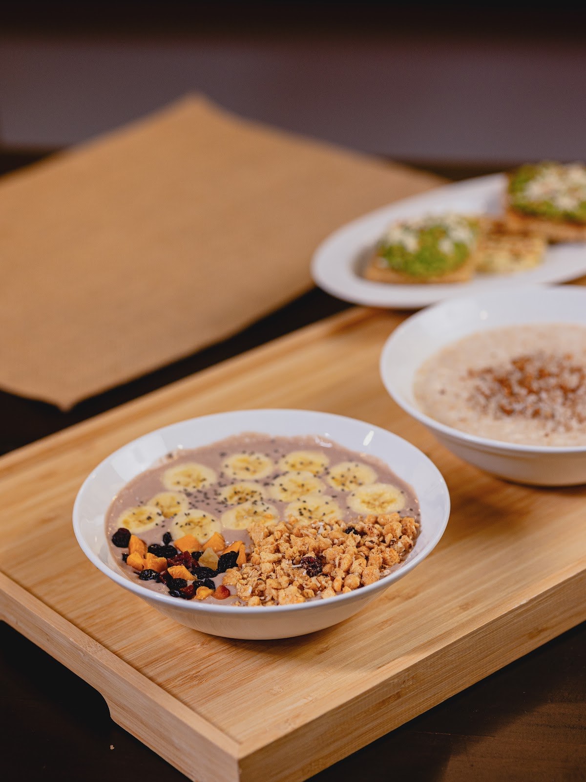A smoothie bowl topped with sliced banana, granola and chia seeds